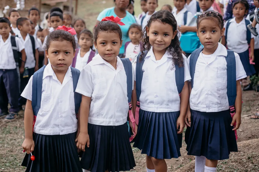 Bambini in divisa scolastica con i nuovi zaini durante una distribuzione di Nissi Project, Honduras
